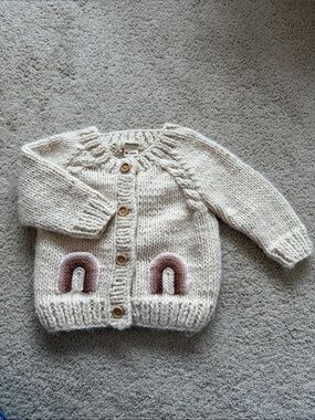 Huggalugs Hand-Knit Cream Baby Cardigan with Rainbow Pockets